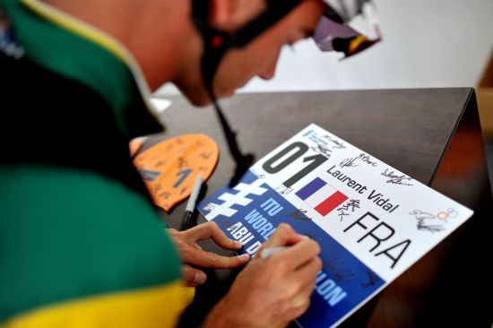 An athlete signs the #1 race number in honour of Laurent Vidal